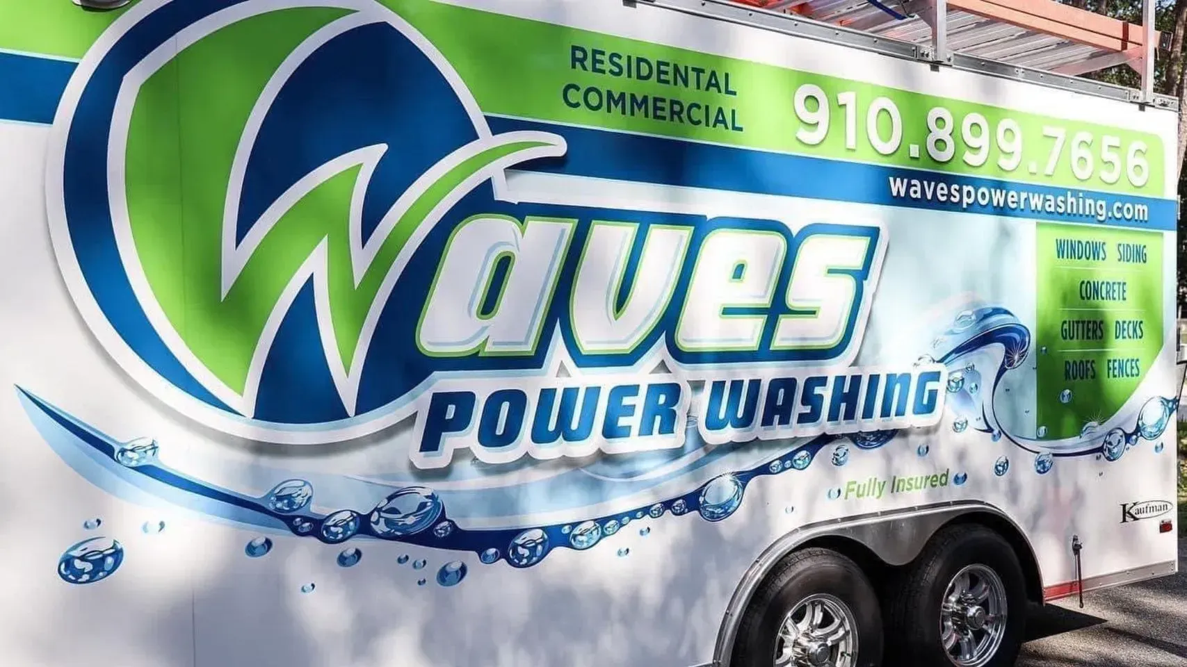 Waves Power Washing trailer with logo and contact info.