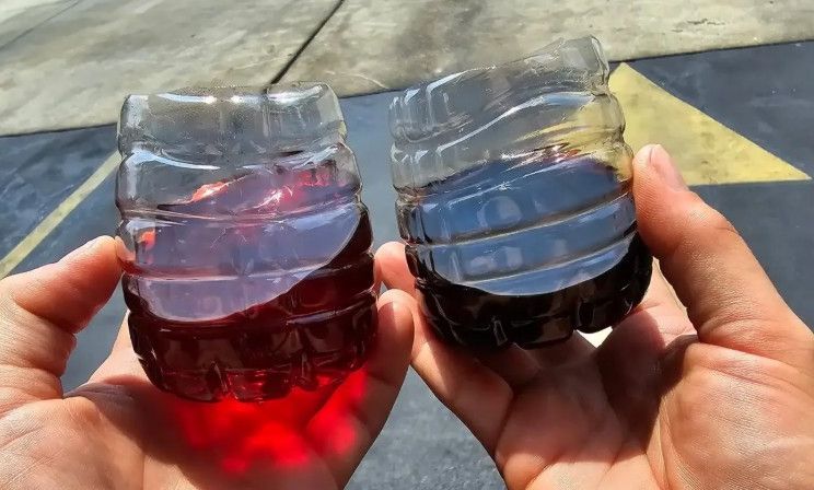 close up image of two cups of transmission fluid, one clean one dirty