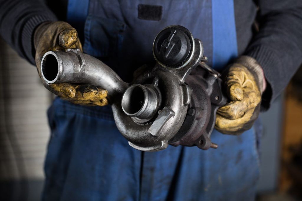 mechanic holding turbocharger