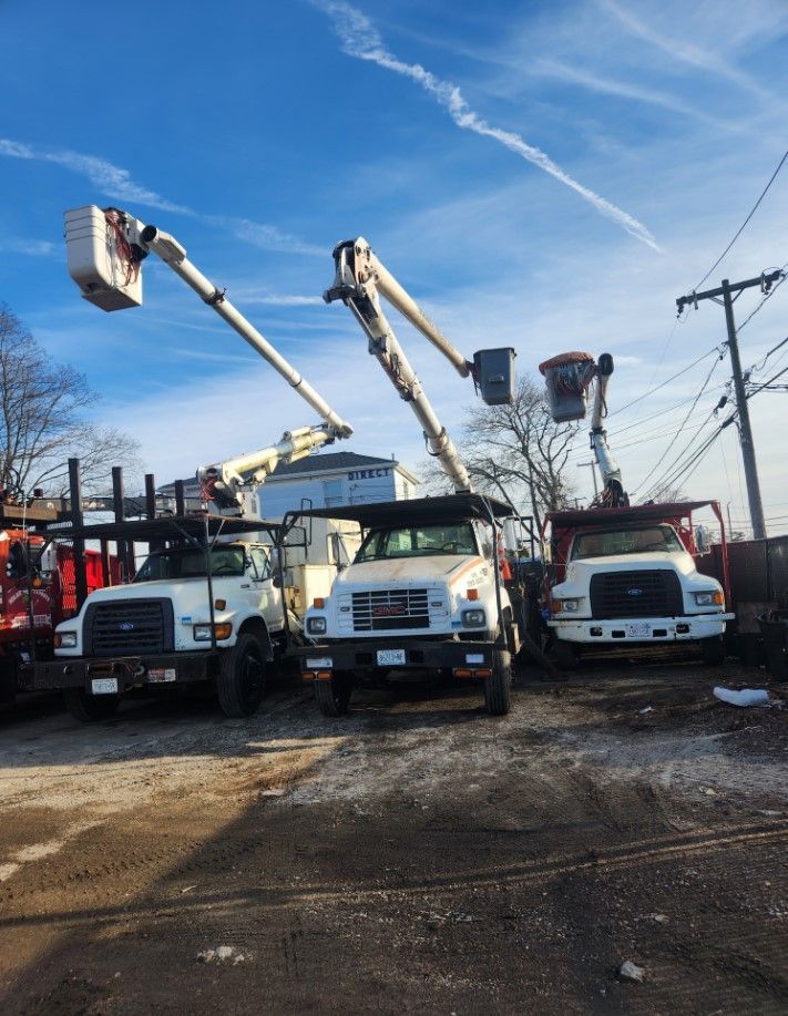 Three trucks with buckets on top of them are parked next to each other