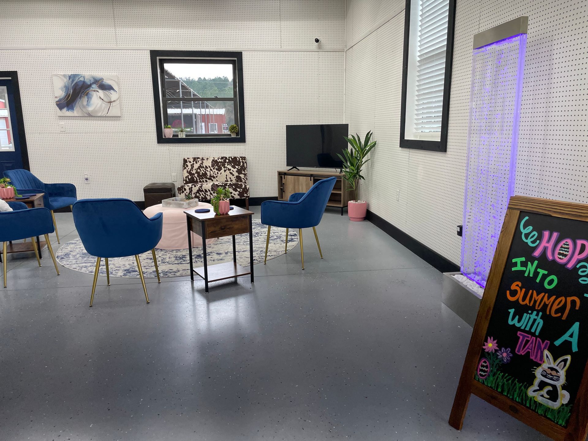 A living room filled with furniture and a sign that says `` hop into summer with a drink ''.