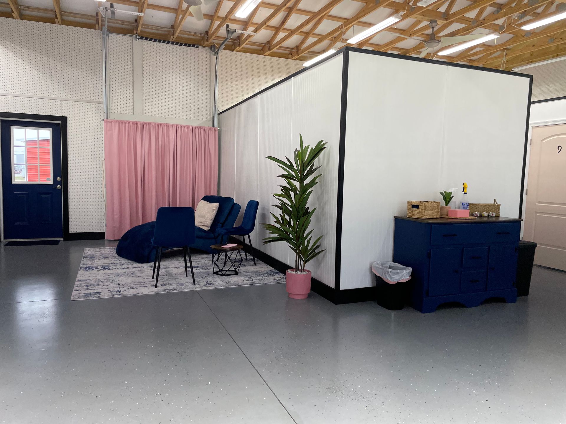 A living room with a couch , chairs , and a plant.
