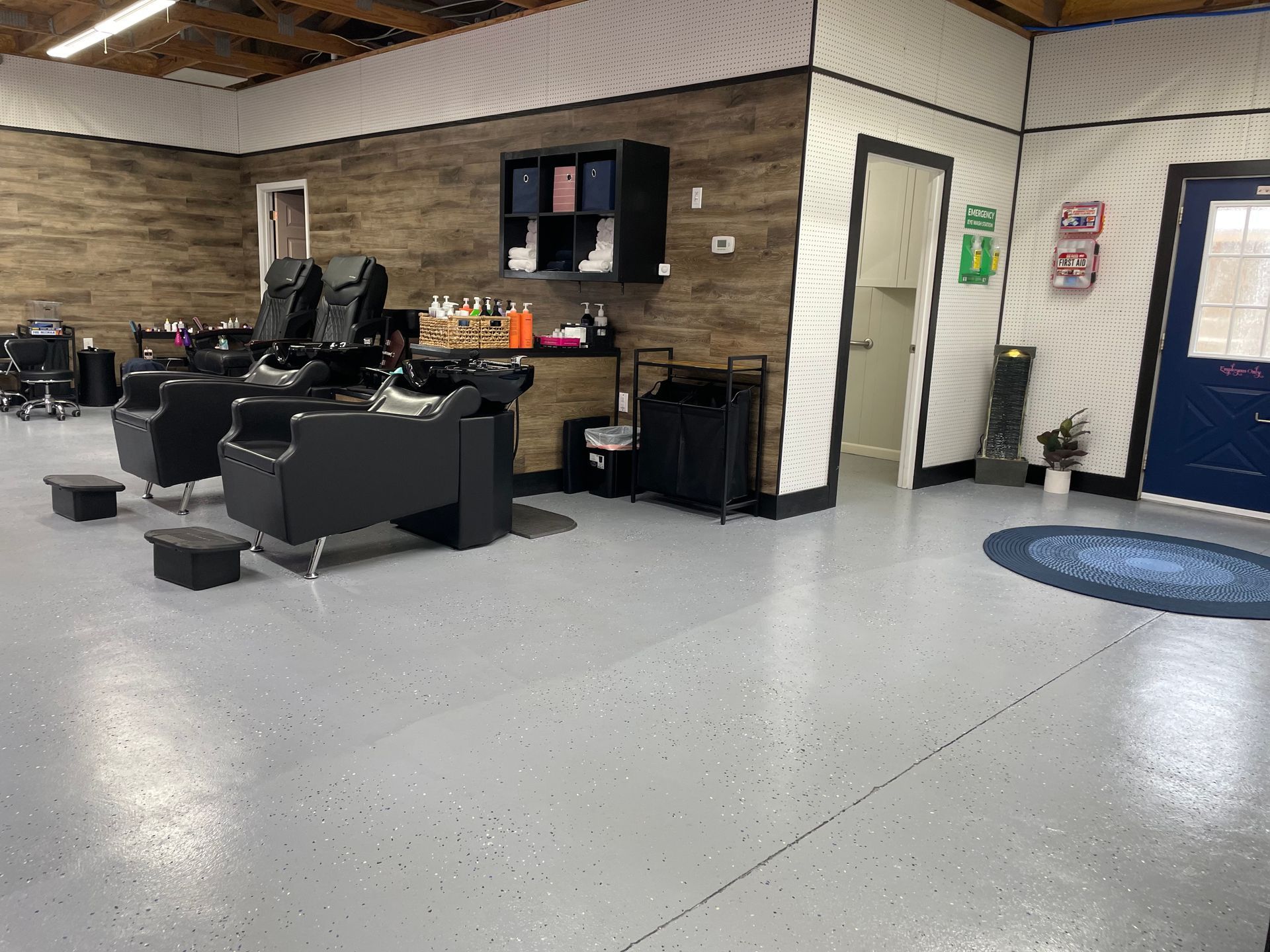 A salon with a lot of chairs and a blue door.