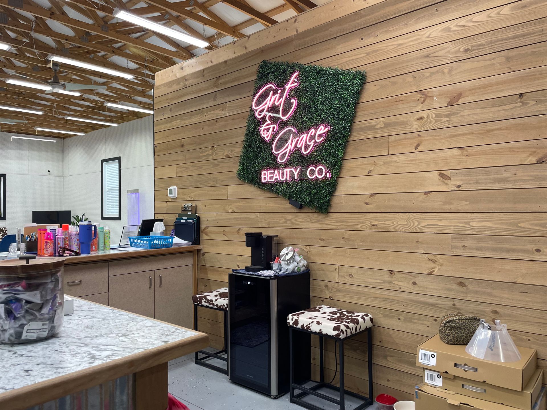 A room with a wooden wall and a neon sign on the wall.