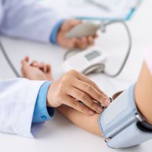 doctor measuring a patient's blood pressure using a sphygmomanometer during a medical checkup.