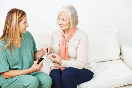 A doctor checking a patient's diabetes by monitoring blood sugar levels using a glucometer