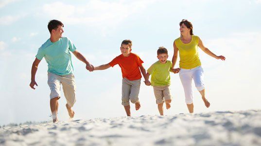 Happy family running on the shore