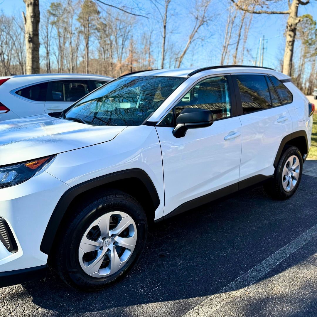 White Toyota RAV4 parked outdoors on a sunny day.