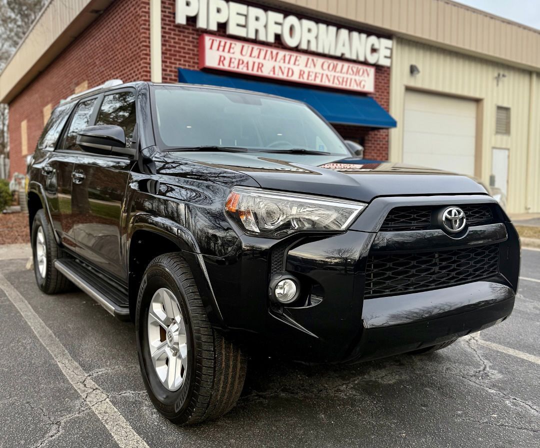 Black Toyota 4Runner SUV parked in front of Piper Performance auto shop.