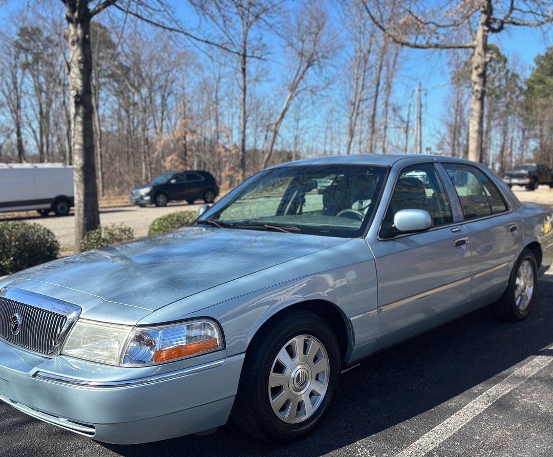 A light blue Mercury Grand Marquis sedan parked on a sunny day.