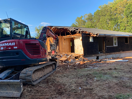 A house is being demolished by a bulldozer.