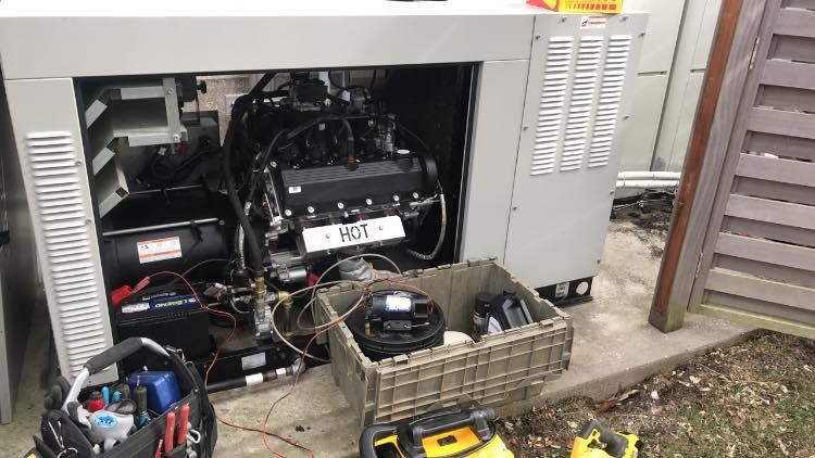 A generator is being repaired with tools and a basket of tools.