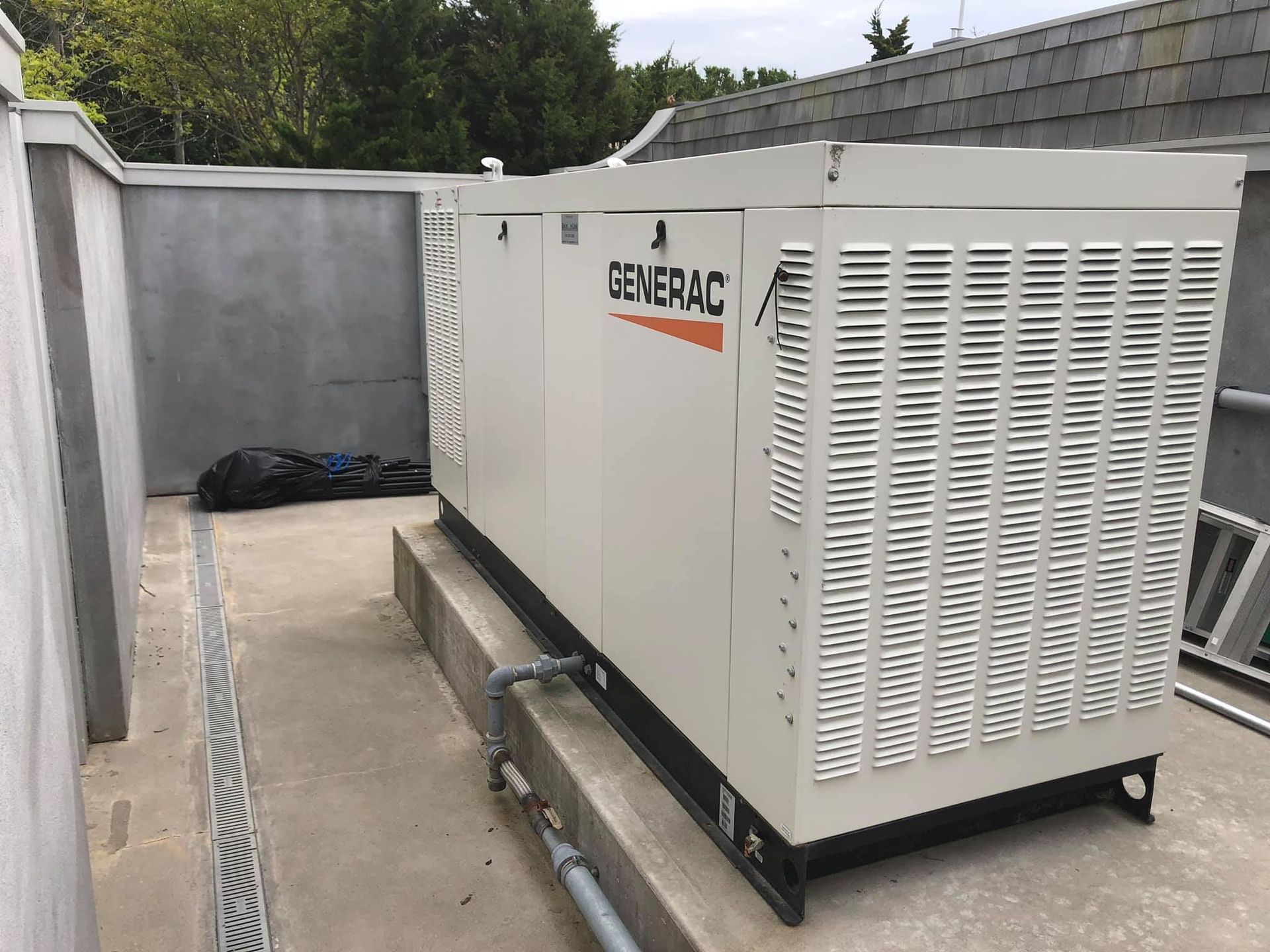 A generator is sitting on the side of a building.