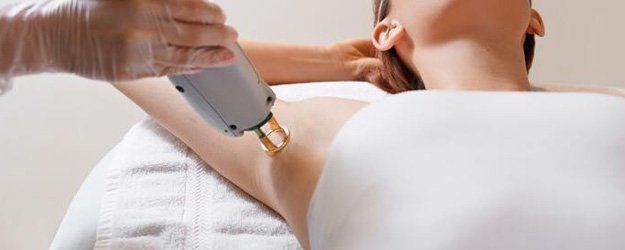 a woman having a laser treatment for her underarm