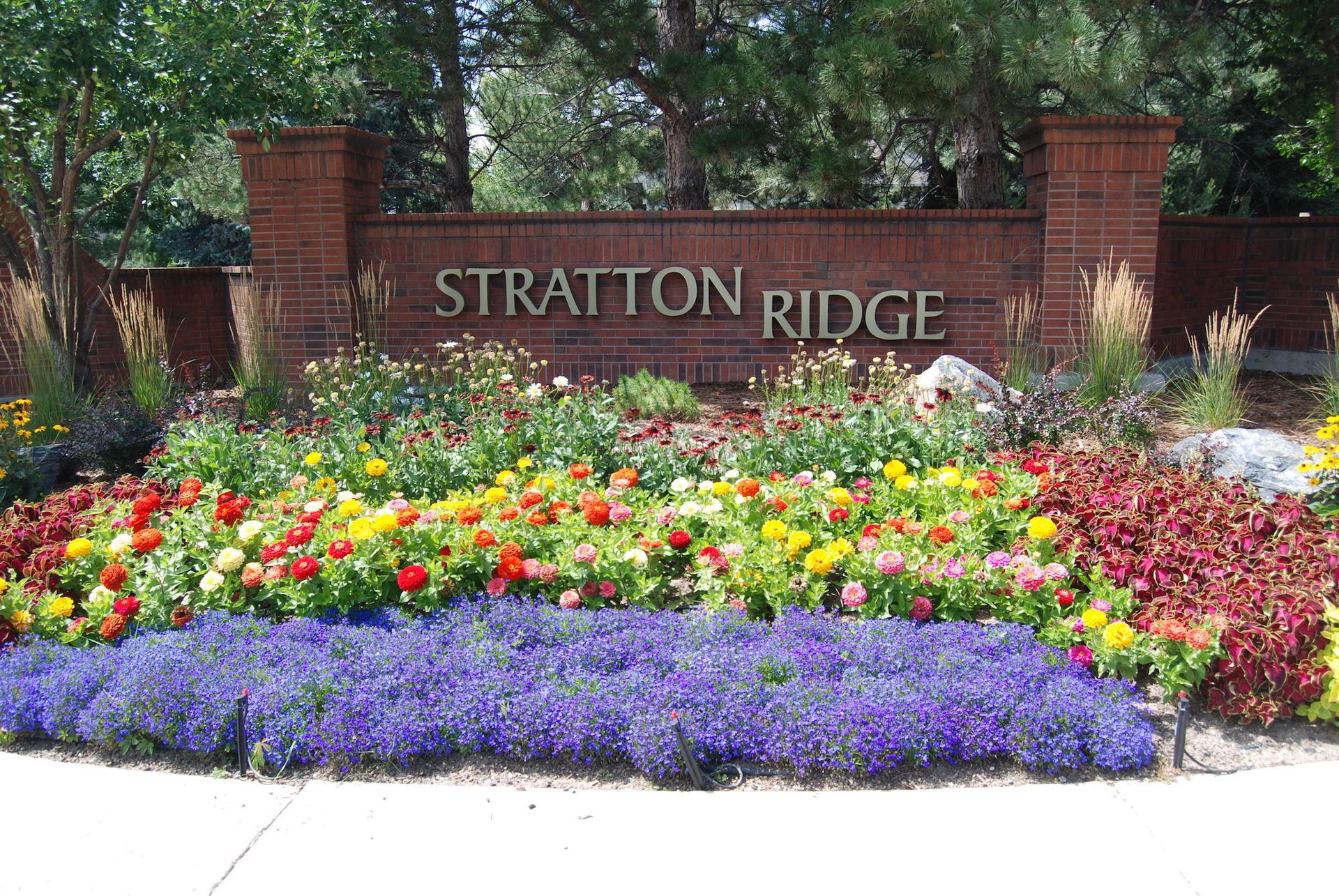 A sign for stratton ridge is surrounded by flowers
