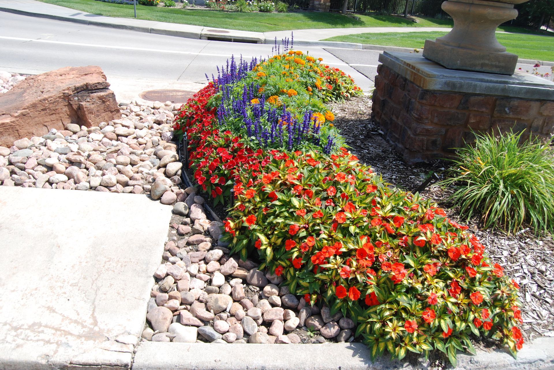A garden with red and purple flowers and rocks