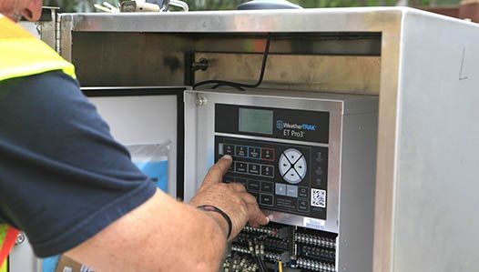 A man in a yellow vest is working on a machine.