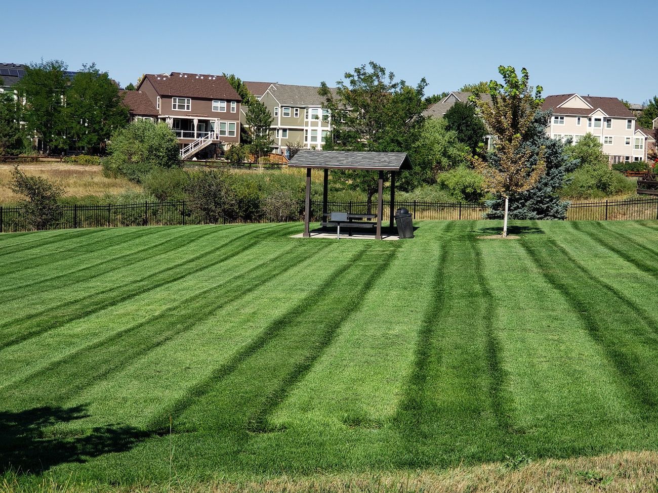 A lush green lawn with a gazebo in the middle of it.