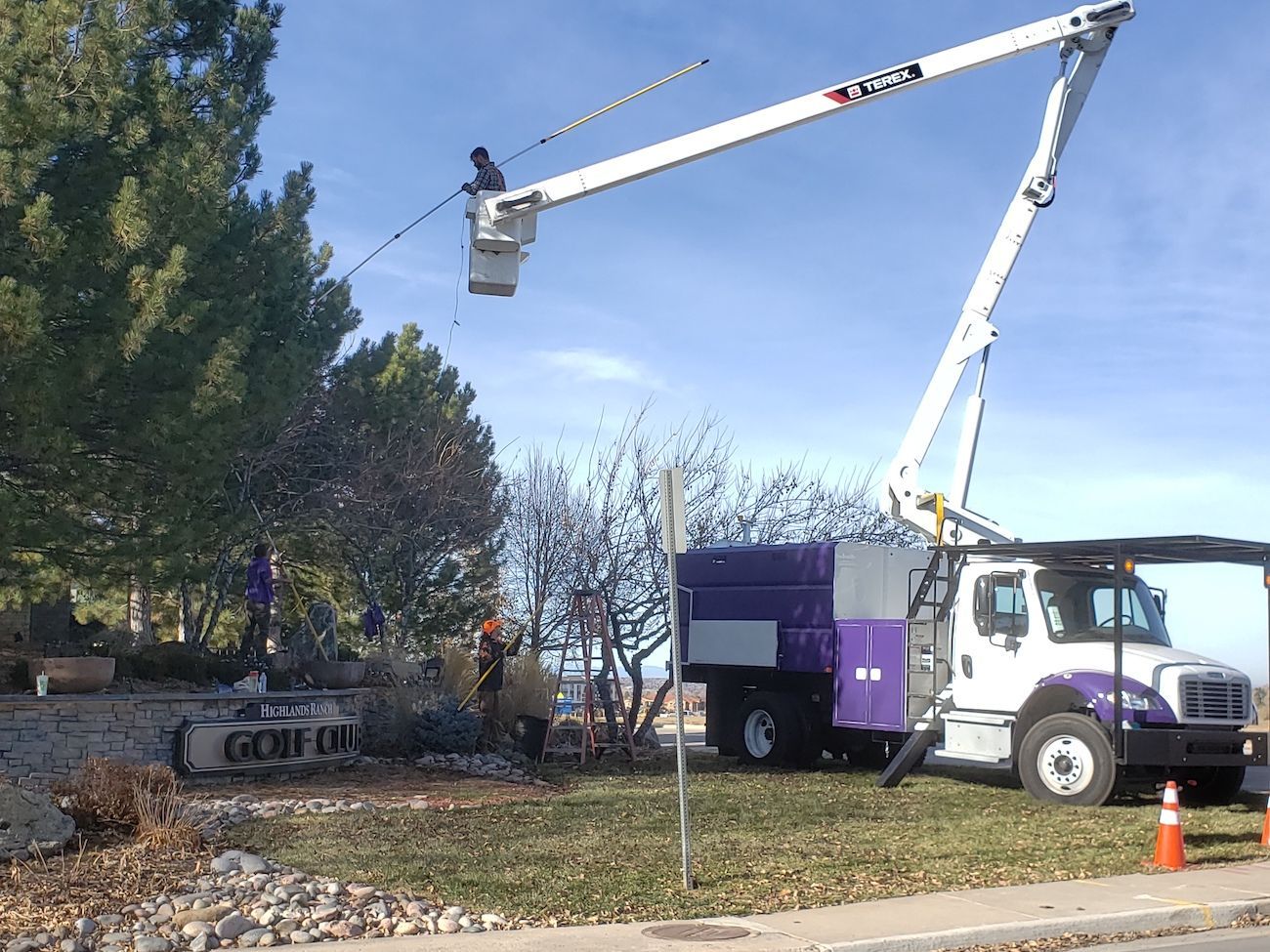 A purple and white truck with a crane attached to it