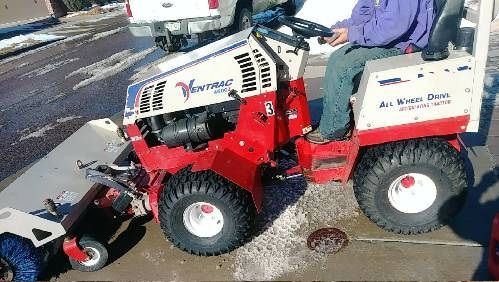 A man is riding a lawn mower that says ' hammer ' on it