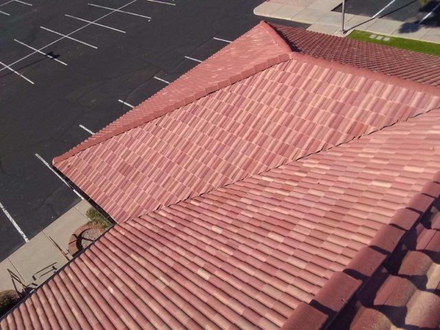 Red-tiled roof viewed from above beside an empty parking lot