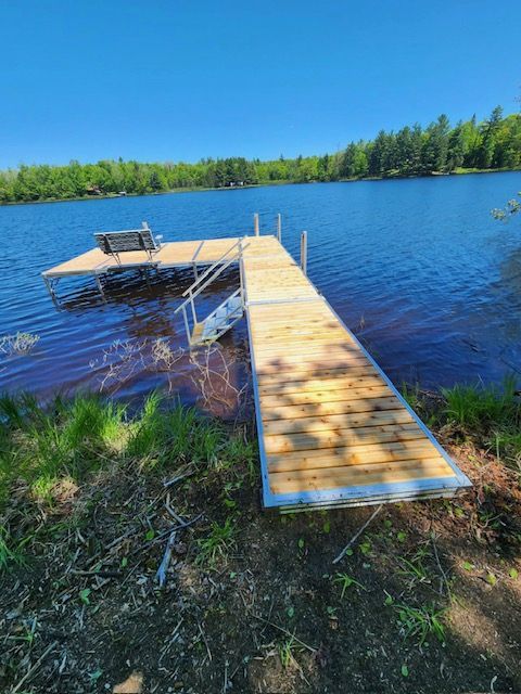 A wooden dock is sitting on the shore of a lake.