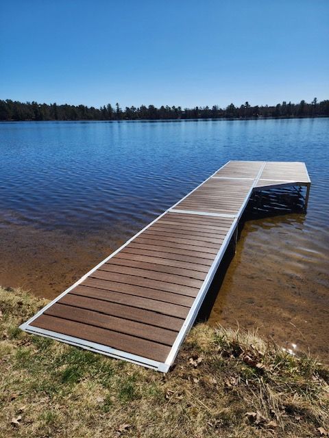 A wooden dock is sitting on the shore of a lake