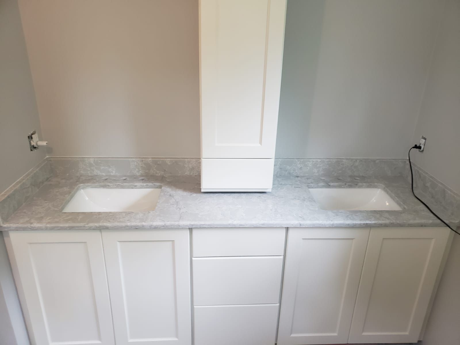 White double sink bathroom vanity with center cabinet on a neutral wall.