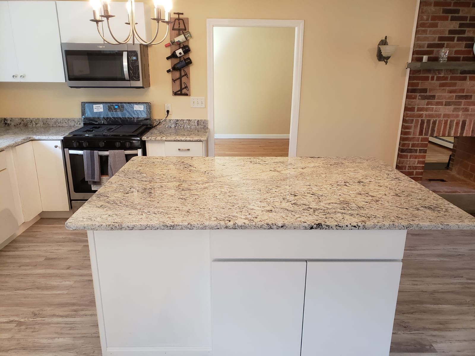 Kitchen with white cabinets, granite countertops, and a central island.