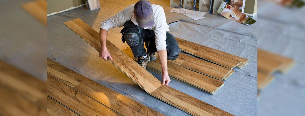man installing planks of hardwood floor