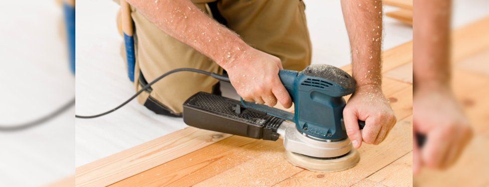 handyman sanding wooden floor