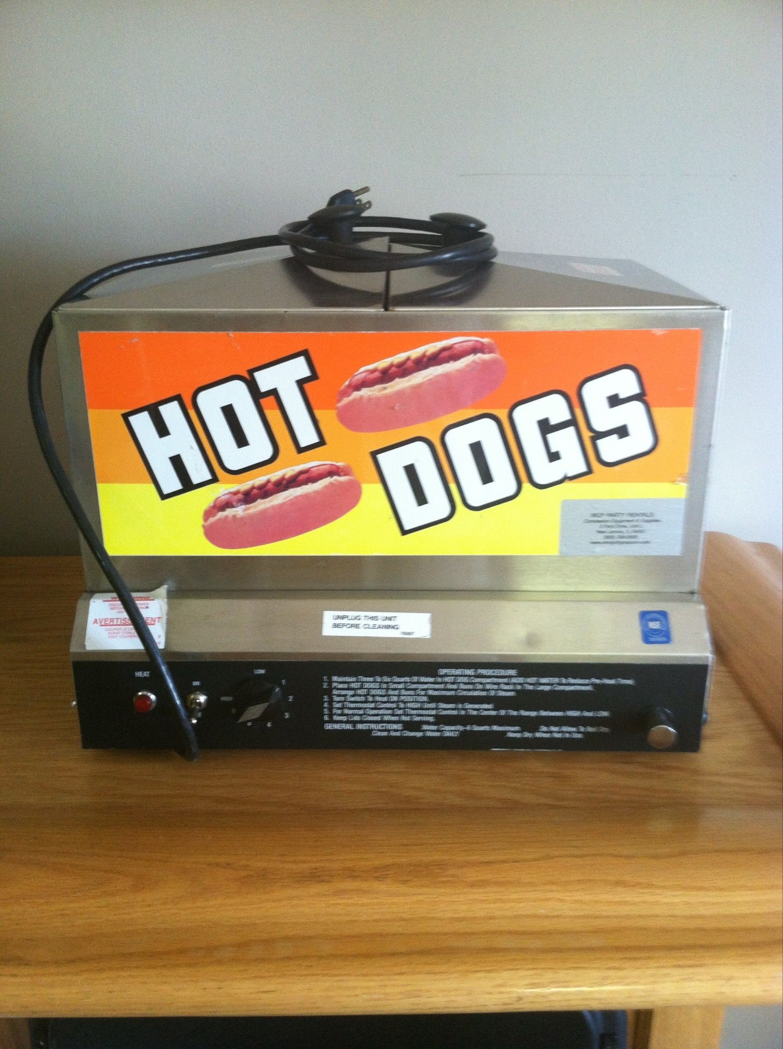 A hot dog machine is sitting on a wooden table