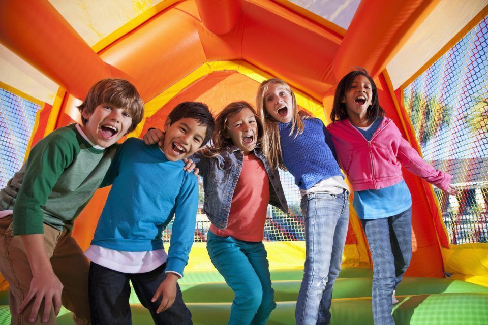 A group of children are posing for a picture in a bouncy house.