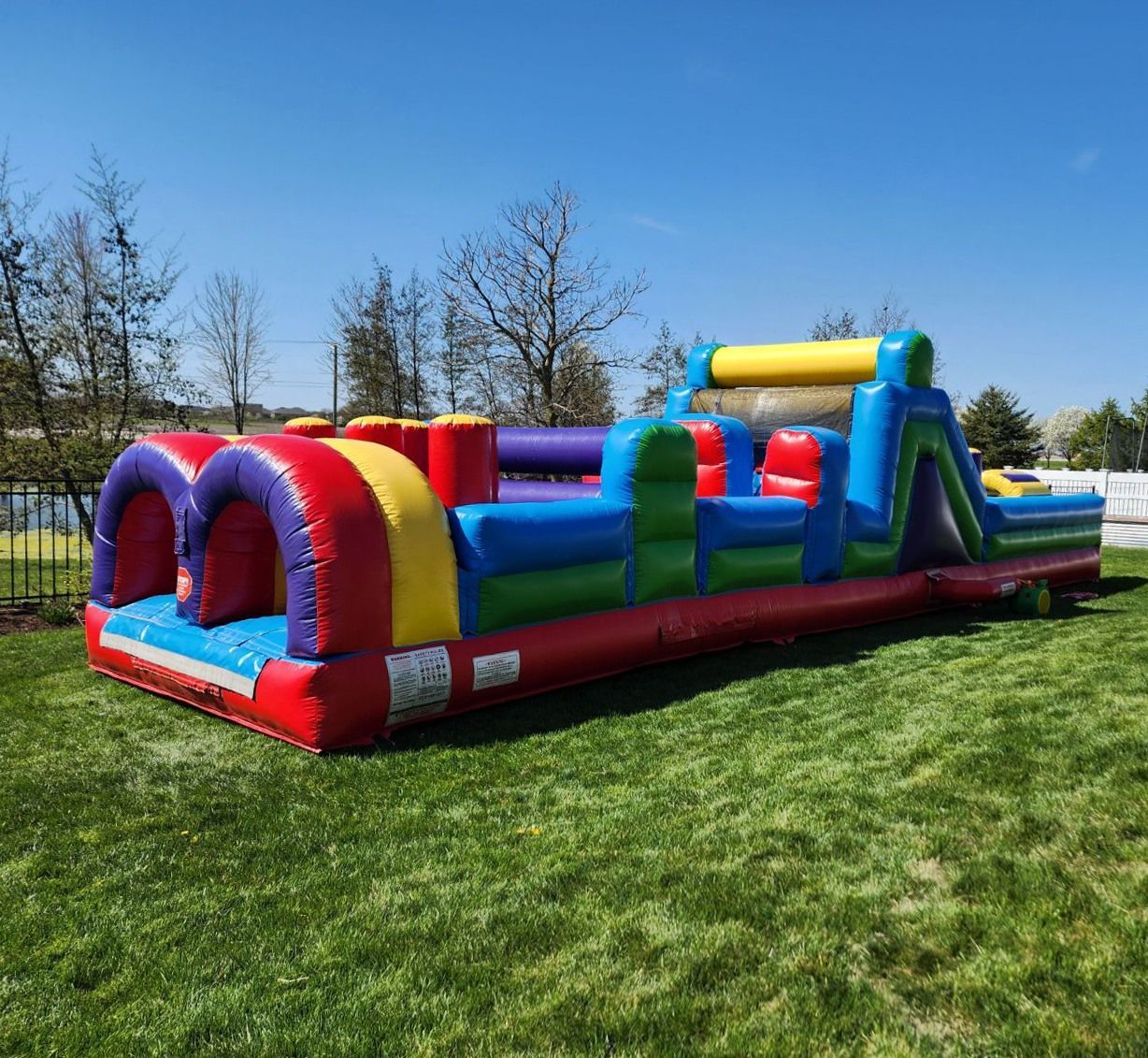 A large inflatable obstacle course is sitting on top of a lush green field.