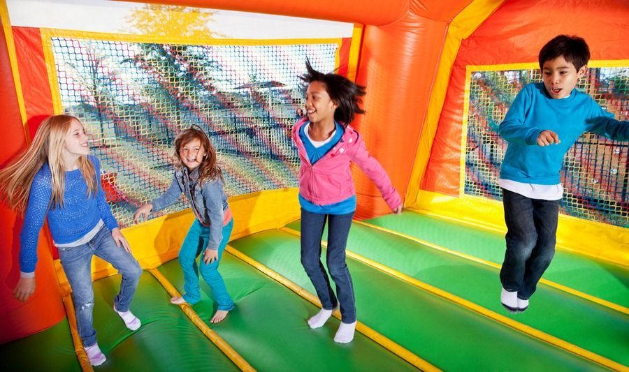 A group of children are jumping in a bouncy house.