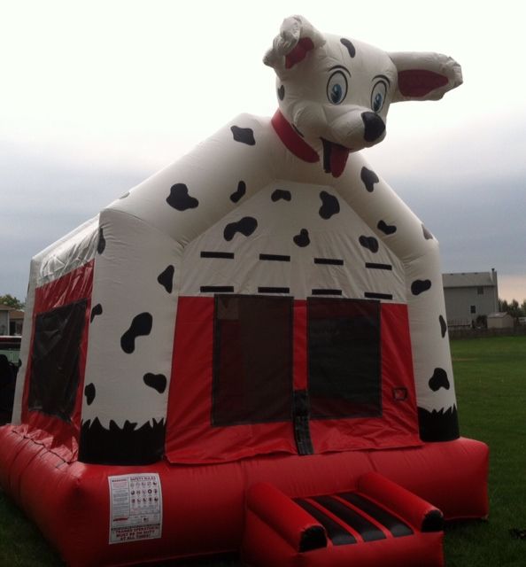 A red and white bouncy house in the shape of a dalmatian dog