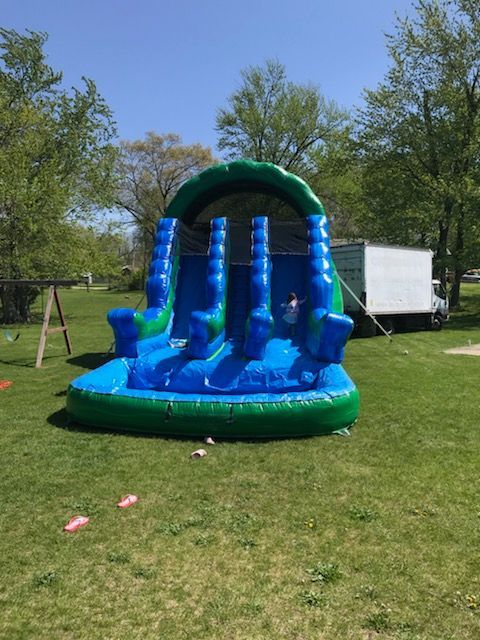 A large inflatable water slide is sitting on top of a lush green field.