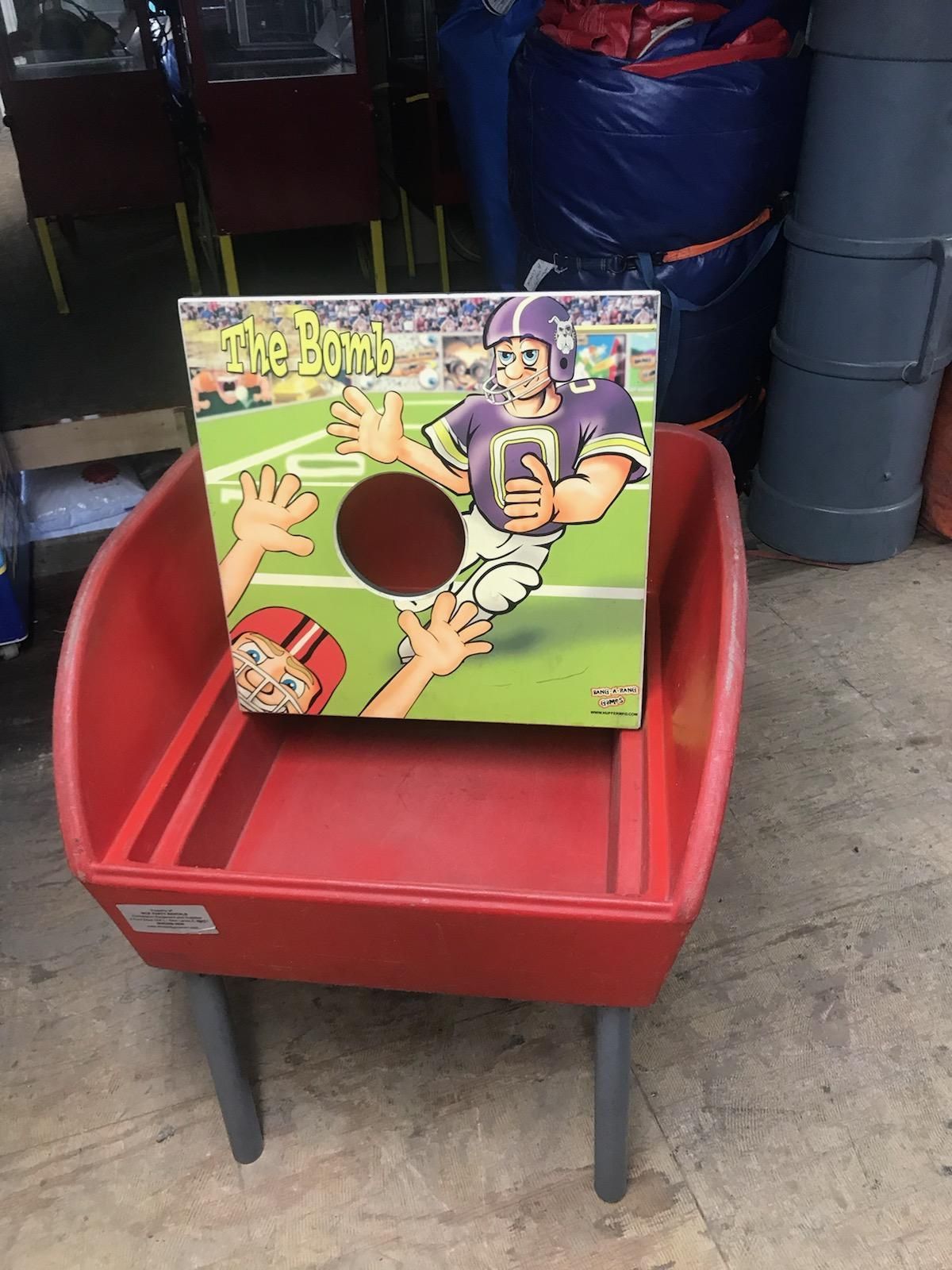 A red wheelbarrow with a football game on it.