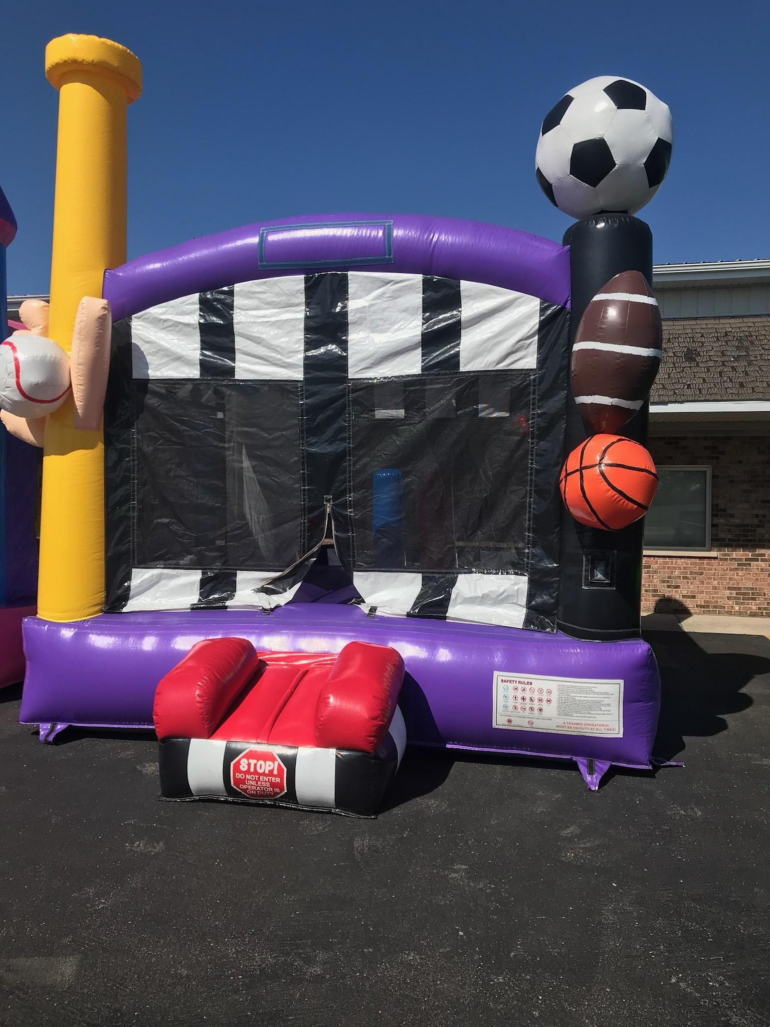 A bouncy house with a soccer ball, basketball, and baseball on top of it.
