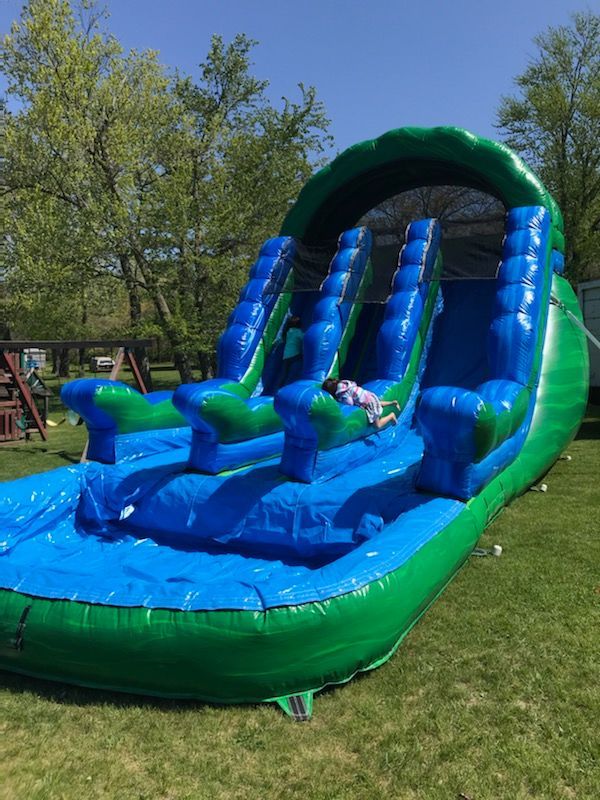 A person is laying on top of an inflatable water slide.