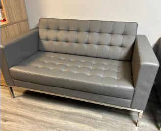 Gray tufted sofa with metal legs in a room with wood flooring