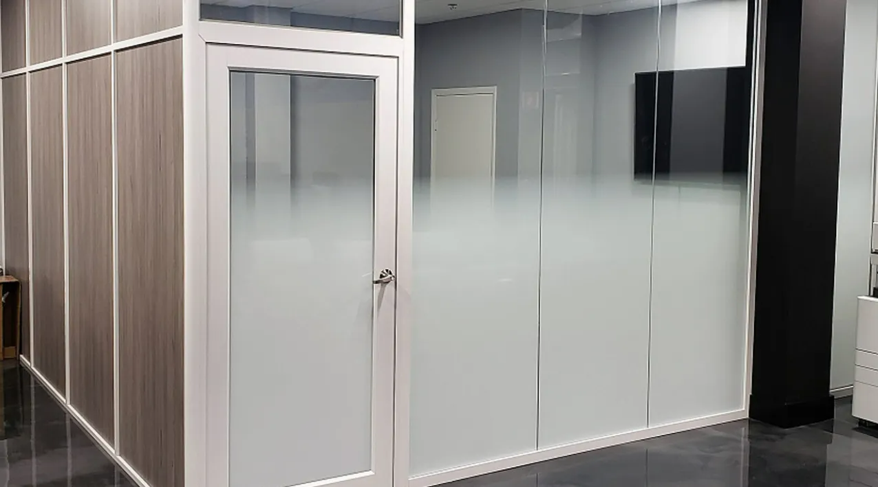 Modern office hallway with frosted glass partition walls and a door