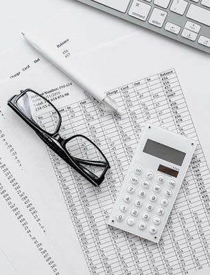 Eye glasses, pen and calculator over tax document