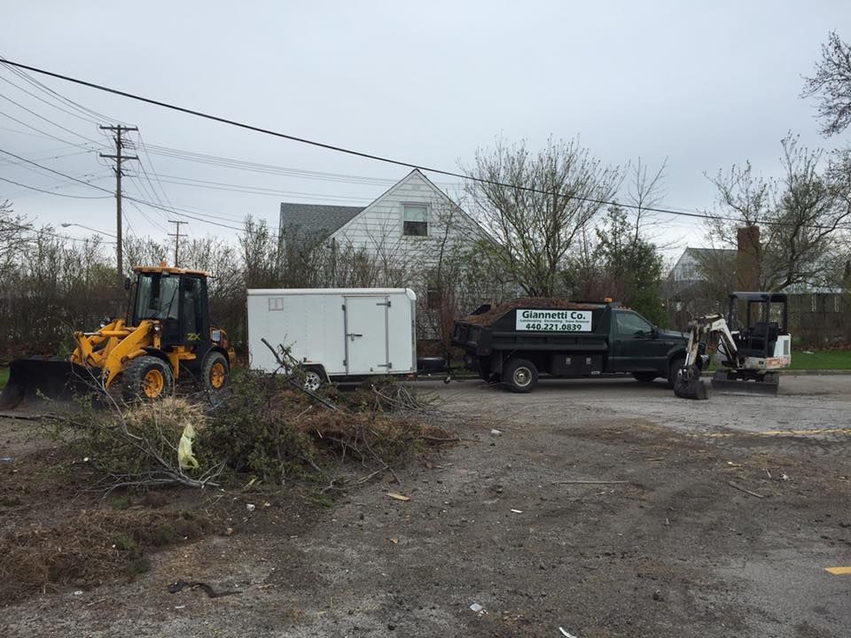 A bulldozer and a dump truck are parked in a dirt lot.