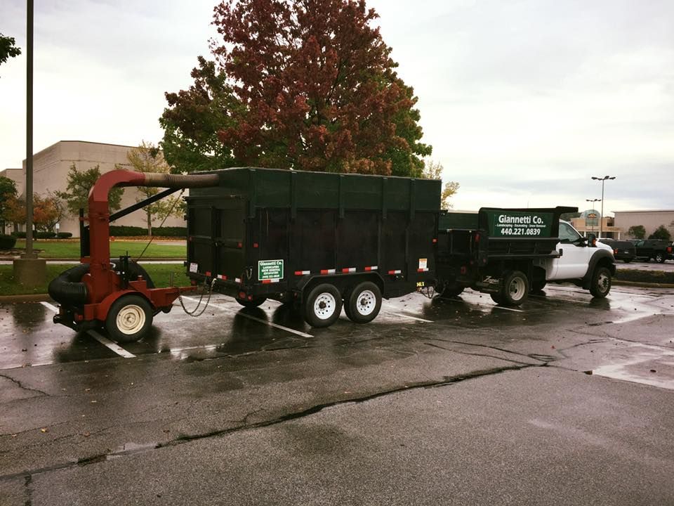 A truck with a trailer attached to it is parked in a parking lot.