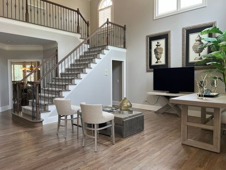 Living area with staircase, hardwood floors, and neutral walls