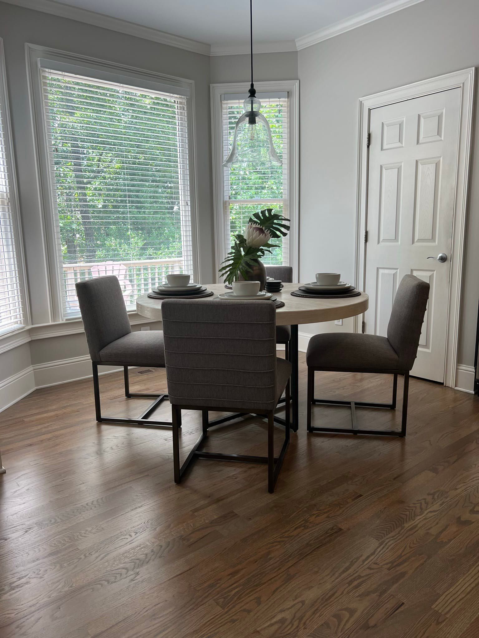 Dining area with round table, three chairs, and a window.