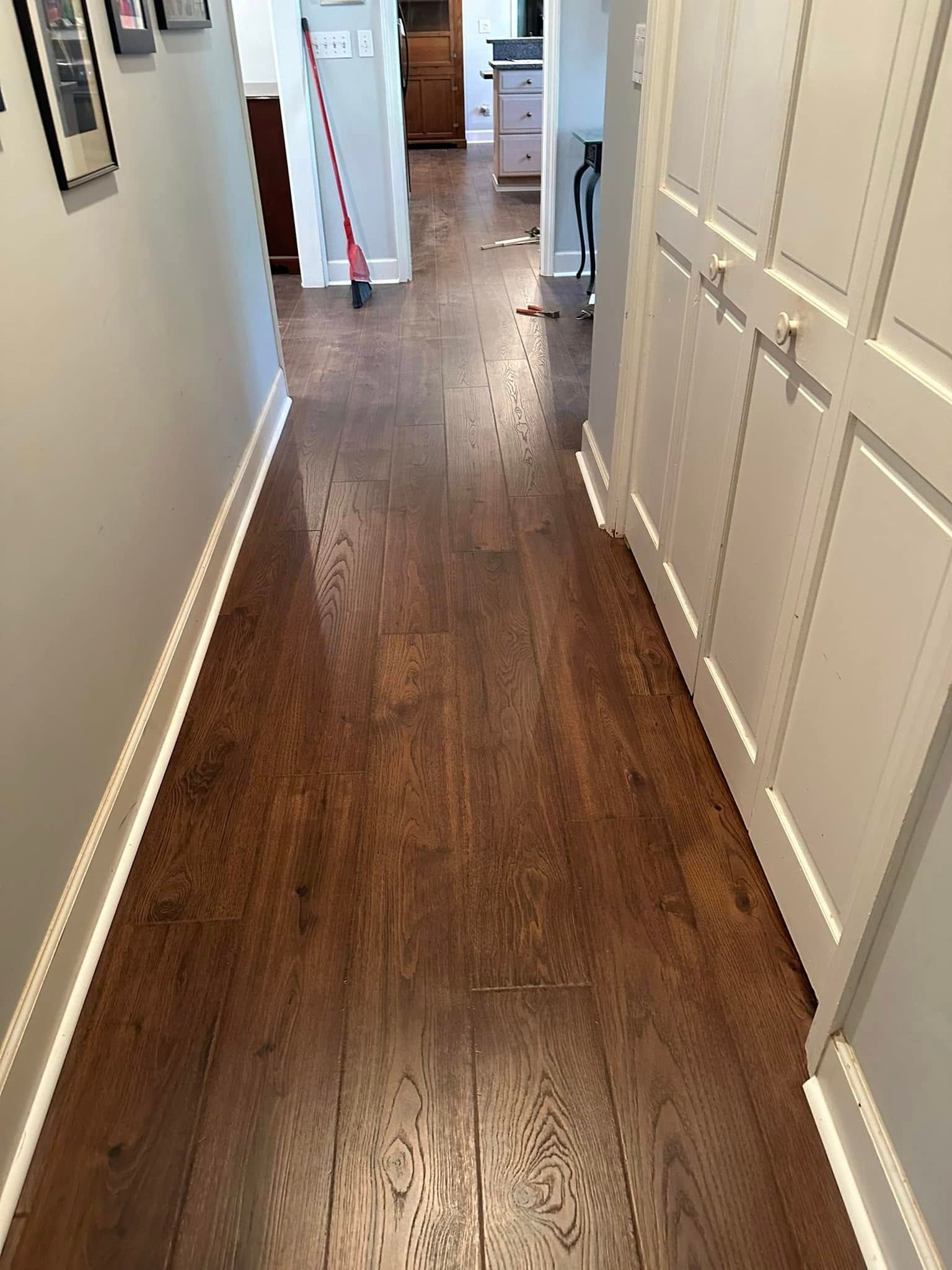 Hallway with dark wood floor, white trim, and a built-in white cabinet.