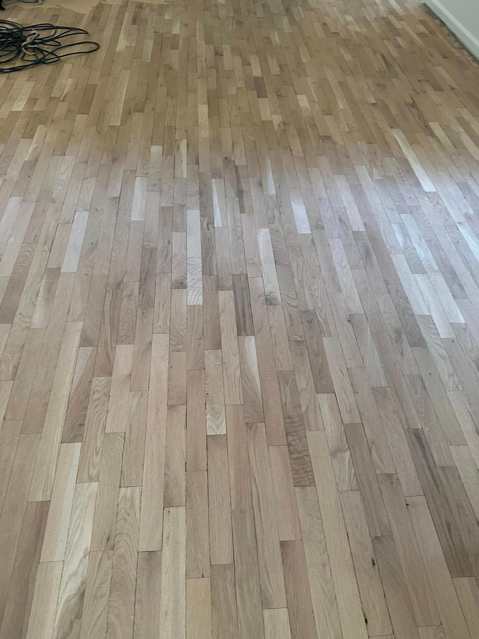 Light-colored hardwood floor with vertical planks.