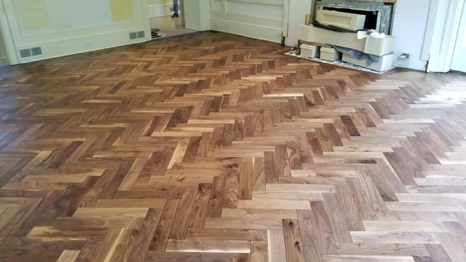 Wooden parquet floor in herringbone pattern, spanning a room.